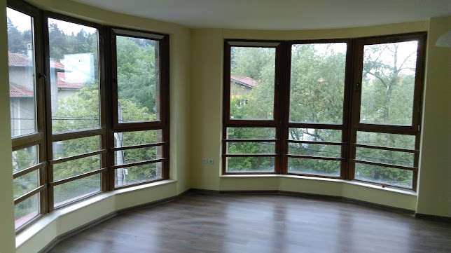 Светла стая с големи панорамни прозорци и дървена дограма