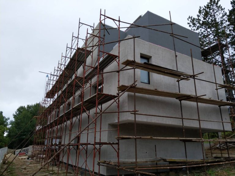 Къща в процес на строителство със скеле около фасадата